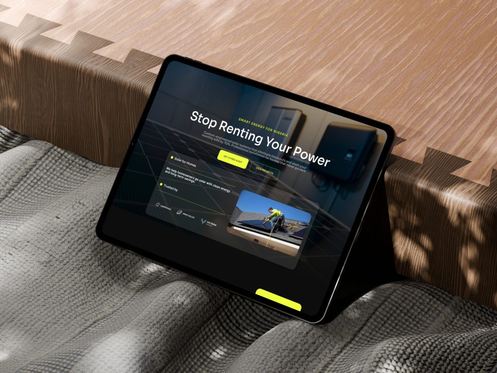 MacBook mockup resting on a green armchair showing a clean, modern solar energy company website design for Nigeria.